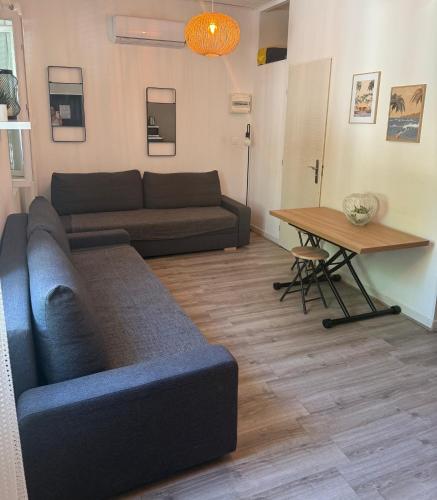 una sala de estar con un sofá y una mesa en Studio BANDOL, en Bandol