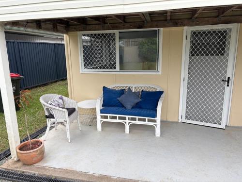 a porch with a blue couch and two chairs at Family Friendly One Bedroom Studio in Brisbane