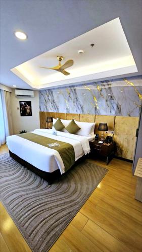 a large bedroom with a large bed with a ceiling at Wright Park Hotel in Baguio
