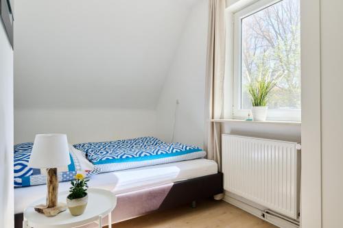 a small bedroom with a bed and a window at Ferienwohnung Trave Ufer Moba-Travel in Lübeck