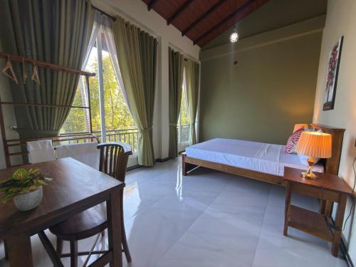 a bedroom with a bed and a table and a window at Sunrise Villa in Kandy