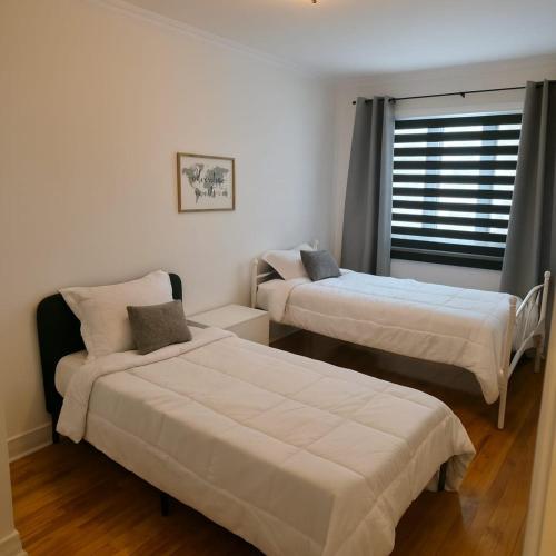 a bedroom with two beds and a window at Appartement cosy, comme à la maison in Montreal