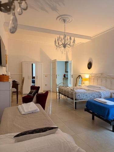 a large bedroom with two beds and a chandelier at San Massimo Apartment - Piazza Duomo L'Aquila in LʼAquila
