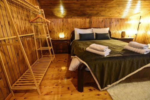 a bedroom with a bed in a wooden cabin at Casa di Fiamengo in Ano Trikala