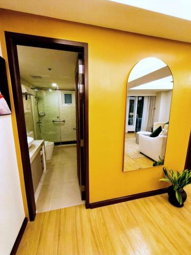 a bathroom with a yellow wall and a mirror at Wright Park Hotel in Baguio