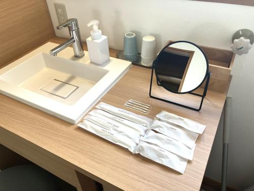 a bathroom counter with a sink and a mirror at Asu base Yuge in Hachimantai