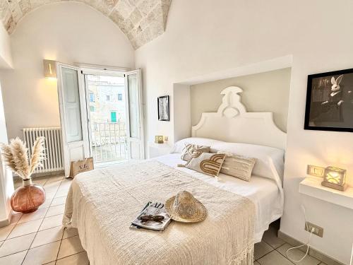 a bedroom with a large white bed and a window at Residenza Garibaldi in Monopoli