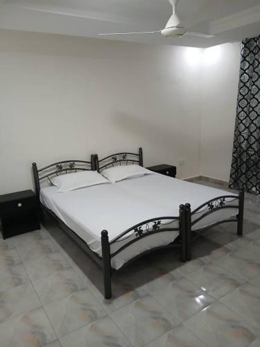 a bed in a room with a white bedspread at Zahra Suites in Elephant Island