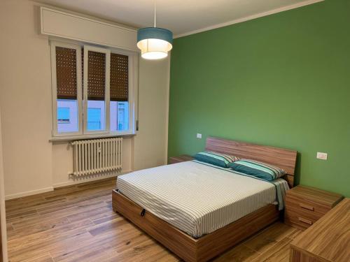 a bedroom with a bed and a green wall at Maison Regina in Vigevano