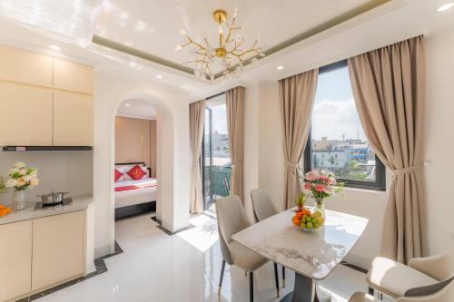 a kitchen and living room with a table and chairs at Bailey Hotel Hue in Hue