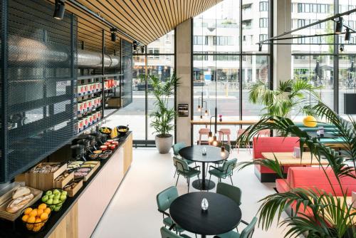 a cafe with tables and chairs in a building at The Social Hub Eindhoven Extended Stay in Eindhoven