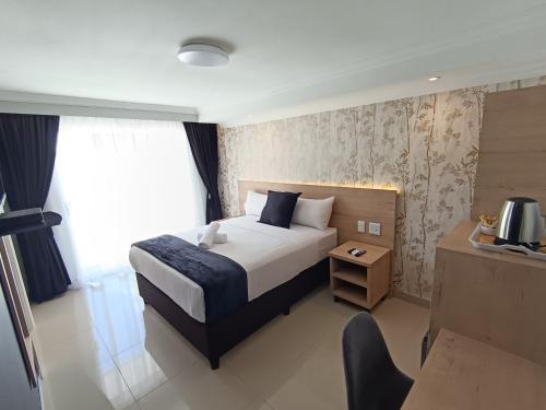a hotel room with a bed and a chair in it at Bayside Hotel Empangeni in Empangeni