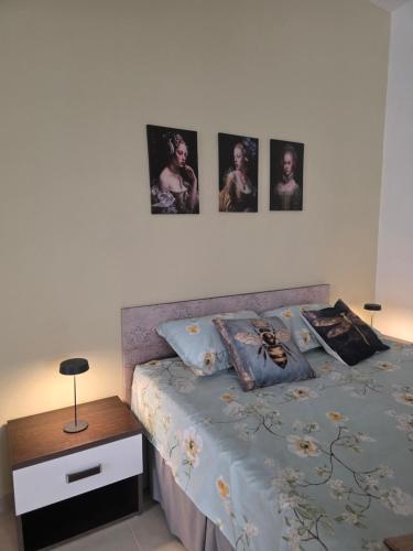 a bedroom with a bed with four pictures on the wall at Appartamento Dancardi in Quartu SantʼElena