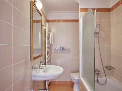 a bathroom with a sink and a toilet and a mirror at Amadria Park Hotel Agava in Opatija