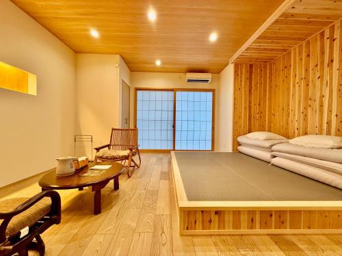 a room with a large bed and a table at 宿坊-地蔵院 in Kurayoshi