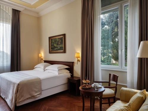 a bedroom with a bed and a table and a couch at Amadria Park Hotel Agava in Opatija