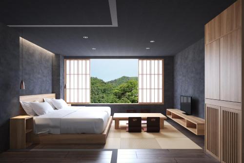 a bedroom with a bed and a large window at Aizu Higashiyama Onsen "Tsuki no Akari" self-service INN in Aizuwakamatsu
