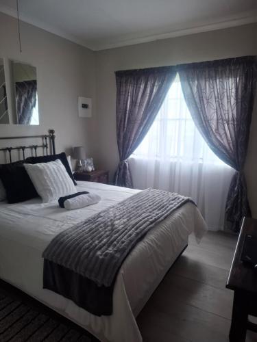 a bedroom with a large bed and a window at 33 On Loop, Flat 2 in Ladybrand