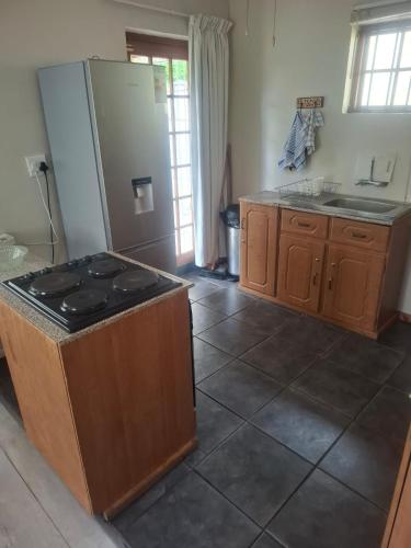 a kitchen with a stove and a refrigerator at 33 On Loop, Flat 2 in Ladybrand