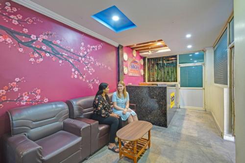 two women sitting on a couch in a waiting room at FabHotel Sri Balaji Grand in Hyderabad