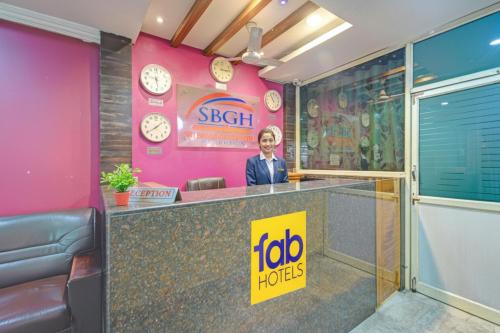 a woman standing behind a counter in a room with clocks at FabHotel Sri Balaji Grand in Hyderabad