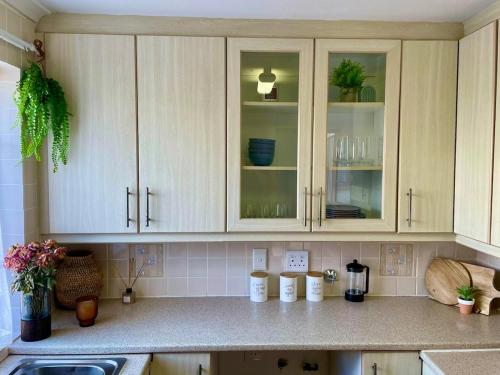 a kitchen with white cabinets and a counter top at Serenity in Fish Hoek