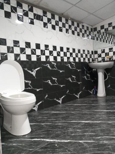a bathroom with a toilet and a sink at Holiday Home Rathnaella in Hassalaka