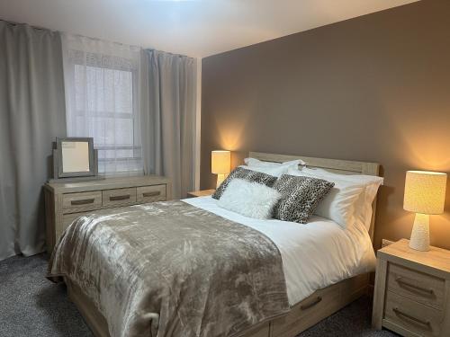 a bedroom with a bed with two lamps and a window at LaScala Apartment in Inverness