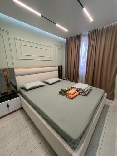 un letto in una camera da letto con due asciugamani sopra di Nomad Home a Bishkek