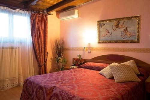 a bedroom with a bed with a red comforter and a window at Villa Altieri in Albano Laziale