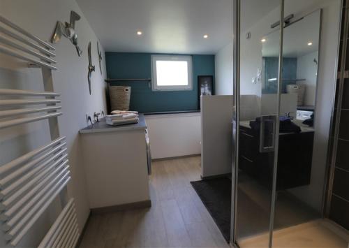 a kitchen with a counter and a glass door at Gite Kalon in Pouldreuzic