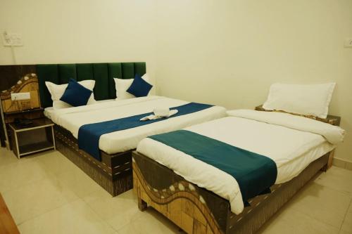 two beds in a hotel room withacers at Hotel Shyam Palace Near Kapurthala Mahanagar Lucknow in Lucknow