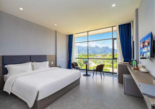 a bedroom with a large bed and a large window at Lisha Garden Resort in Vang Vieng