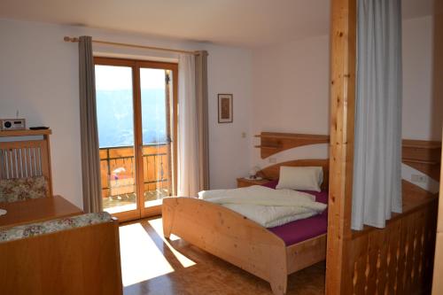 a bedroom with a bunk bed and a balcony at Kastnerhof in Meltina