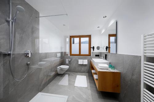 a bathroom with a shower and a toilet and a sink at Hotel Garni Paler in Tirolo