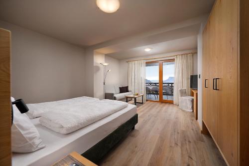 a hotel room with a bed and a balcony at Hotel Garni Paler in Tirolo