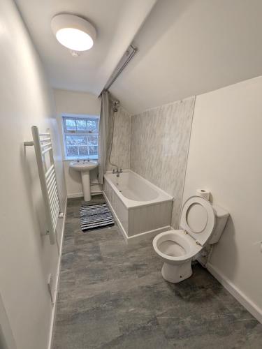 a bathroom with a toilet and a tub and a sink at Tredegar Arms Budget Guesthouse For Walkers/Cyclists/Contractors/Traveler in Merthyr Tydfil