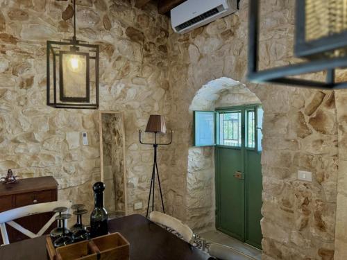 a room with a green door in a stone wall at Beit El Berbara-Pool & Breakfast in Al Ḩulwah