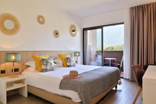 a hotel room with a bed with a hat on it at Hôtel San Lucianu in Moriani Plage