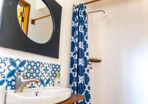 a bathroom with a sink and a mirror at Gecko Cottage - Cosy 2-Bedroom in Bagamoyo Old Town in Bagamoyo