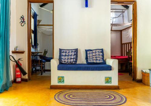 a living room with a couch and a mirror at Gecko Cottage - Cosy 2-Bedroom in Bagamoyo Old Town in Bagamoyo