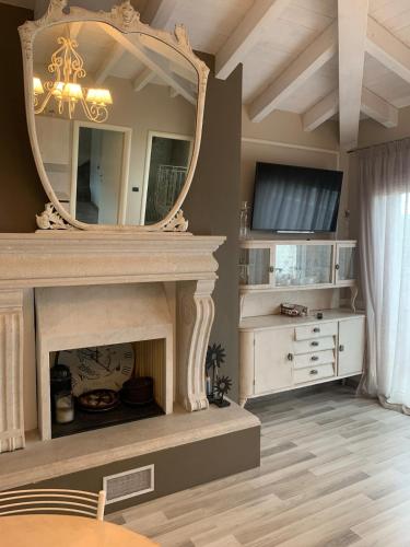 a living room with a fireplace and a mirror at Penthouse Apartment Desenzano in Desenzano del Garda