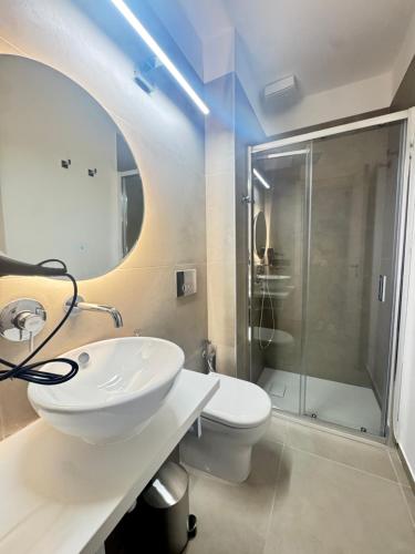 a bathroom with a sink and a toilet and a shower at Kymata Home in Avola