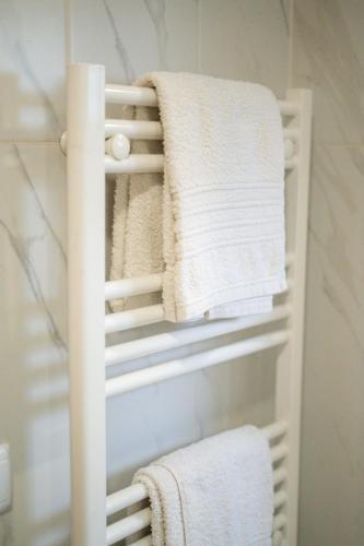 a towel rack in a bathroom with white towels at Sousa Horizonte - Louredo in Vieira do Minho