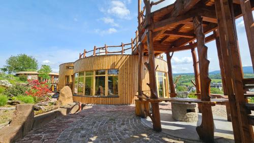 a large wooden house on a hill with a patio at dům Ohně in Prostřední Lánov