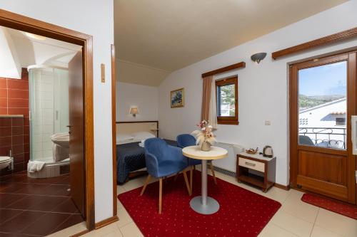 a bedroom with a bed and a table and a bathroom at SEGET ESTATE Beachfront Oasis & Tradition since 1964 - Split Trogir Riviera in Trogir