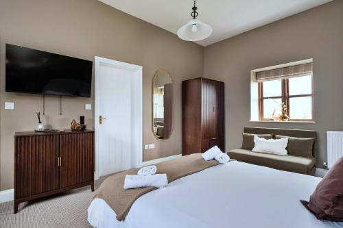 a bedroom with a large bed and a television at Finest Retreats - The Park in Onibury