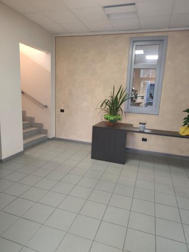 a waiting room with a potted plant and a mirror at The Polo Hub in Mortara