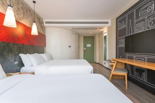 a hotel room with two beds and a flat screen tv at Ibis Chengdu Wuhouci Jinli in Chengdu