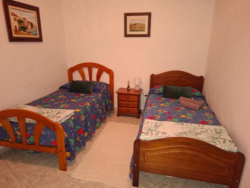 a bedroom with two beds and a night stand with a bedskirts at Solo Tranquilidad in Mocanal